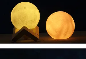 Comparison of two 3D moon lamps in yellow and orange glowing in a dark setting