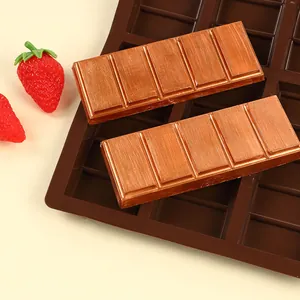 Detailed view of 6-cavity chocolate silicone mold with finished bars and strawberries