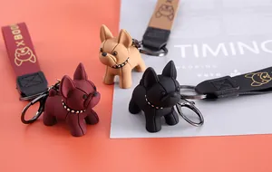 Gros plan de porte-clés bouledogue français en résine de trois couleurs avec lanières.