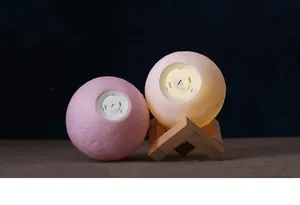 Detail view of the bottom charging port on 3D moon night lights with wooden stand