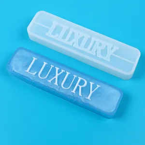 Detailed view of white silicone mold and blue resin 'LUXURY' word ornament