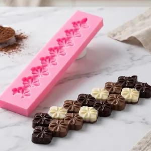Primer plano detallado del molde de silicona de flor de cerezo con bombones caseros.