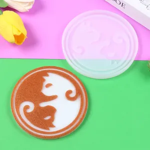 Macro detail showing the cat-patterned silicone mold and a finished resin coaster