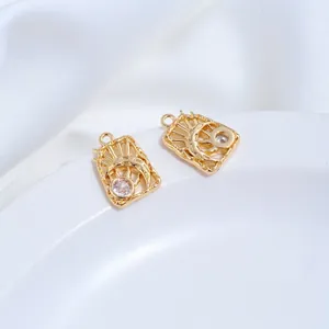 Detail showing 14K gold-plated celestial sun and moon charms with clear zirconia stones