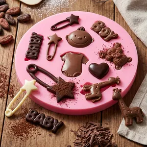 Detailed view of pink baby themed silicone mold with finished chocolate cake toppers