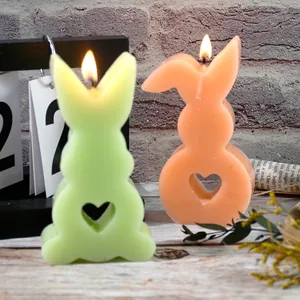 Close-up of burning rabbit candles with heart-shaped cutouts for festive Easter home decor.