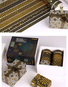 Macro view of black and gold bronzing washi tape rolls in a gift box packaging