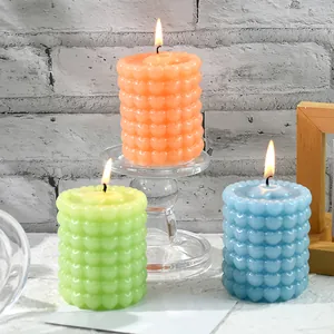 Gros plan de bougies d'aromathérapie à motif de cœur texturé dans des tons pastel sur support chic