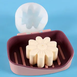 Detailed view of daisy silicone mold with finished flower-shaped soap piece in soap dish