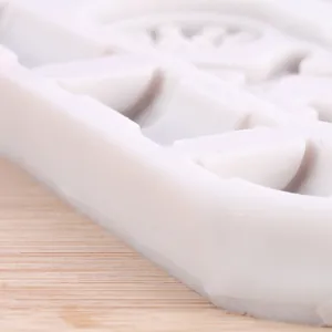 Vue macro montrant les bords épais et la texture du moule en silicone blanc pour engrenage