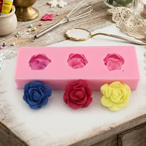 Détail du moule à roses en silicone rose avec fleurs finies bleues, rouges et jaunes