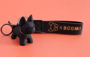 Gros plan d'un porte-clés bouledogue noir mat avec une lanière en cuir noir XBOOM!