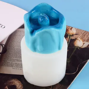 Dettaglio dello stampo in silicone con candela blu su sfondo blu chiaro.