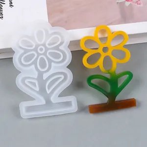 Detailed view of a sunflower silicone mold next to its colorful finished resin craft