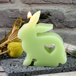 Detailed view of light green Easter bunny candle with heart cutout on a grey stone slab