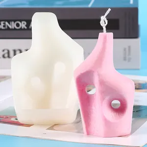 Gros plan sur la bougie abstraite rose et le moule en silicone blanc pour déco DIY