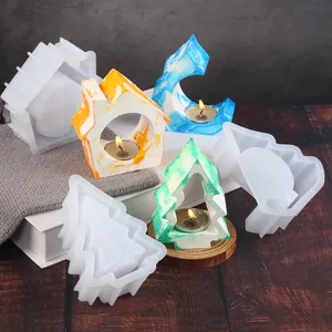 Detailed shot of Christmas tree and house shaped silicone molds for DIY resin candle holders.