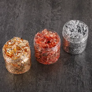 Close-up of gold, rose gold, and silver metallic foil flakes in clear jars for DIY crafts