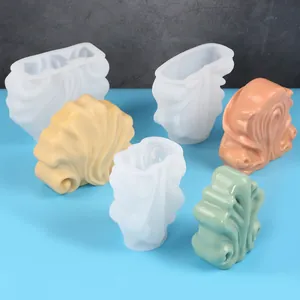 Detailed view showing DIY shell-shaped silicone molds and finished resin candle crafts