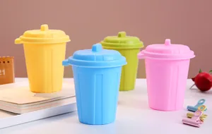 Four colorful mini desktop trash cans with lids for desk organization and storage