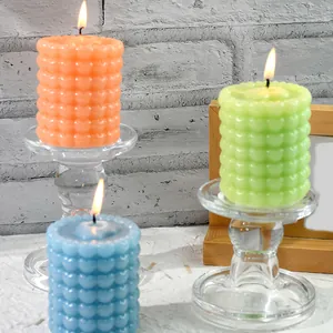 Gros plan détaillé de bougies bulles à motif de cœur faites main en orange, vert et bleu.