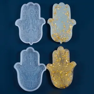 Dettaglio degli stampi in silicone Hamsa e pezzi in resina finiti con foglie d'oro