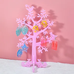 Vari orecchini colorati in resina a forma di foglia su un supporto ad albero