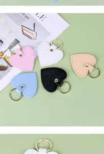 Gros plan de porte-clés en cuir en forme de coeur de différentes couleurs avec anneaux dorés