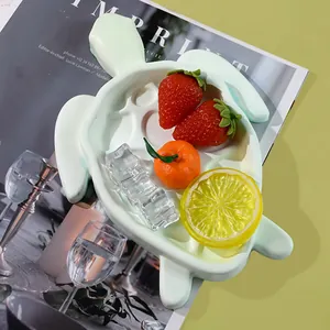 Detailopname van een mintgroen schildpad-dienblad met decoratief fruit en ijsblokjes