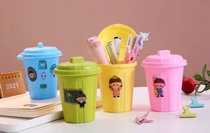 Group of colorful mini trash can shaped pen holders arranged on a desk with school supplies