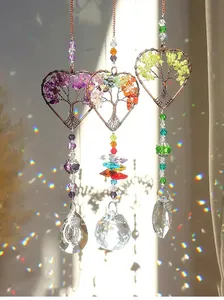 Heart-shaped Tree of Life crystal suncatchers reflecting beautiful rainbow light on a wall