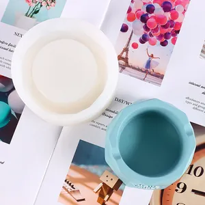 Close-up of a white silicone mold and a blue hexagonal plaster pot with embossed text.