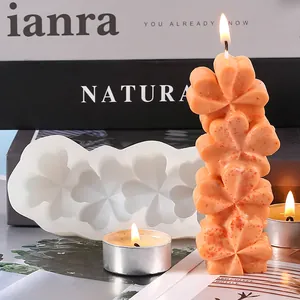 Detailed view of a five-connected heart clover silicone mold with a finished orange candle.