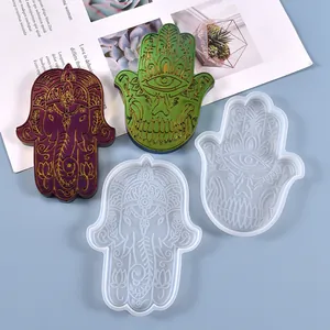 Vista dettagliata di stampi in silicone mano di Hamsa con campioni di resina finiti