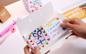 Detailed view of hands opening a creative DIY bouncing explosion box with messages.