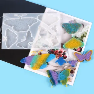Dettaglio dello stampo in silicone a farfalla per resina con farfalle in resina colorate.