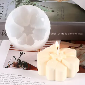 Detailed view of a white flower-shaped silicone mold alongside a finished candle