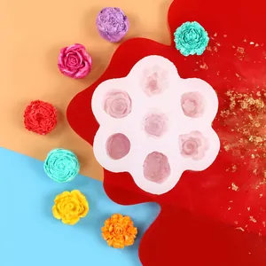 Molde de silicona floral multi-cavidad con flores de cera sobre un fondo de colores