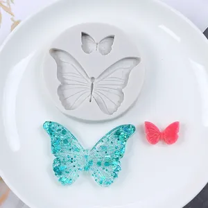 Detailed view of butterfly silicone mold with glitter resin and pink clay samples