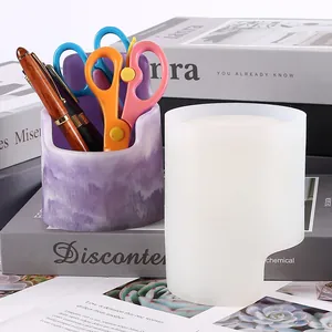 Close-up of DIY chair-shaped silicone mold and finished marbled resin pen holder on a desk