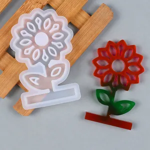 Detail view of a sunflower silicone mold alongside a finished red resin flower piece