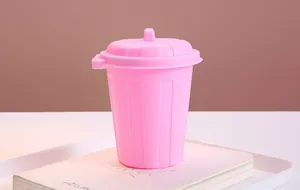 Close-up of a creative pink mini desktop trash can used as a decorative pen holder