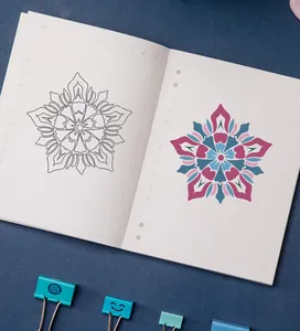 Mandala stencil application showing both line art and colorful pattern on notebook pages
