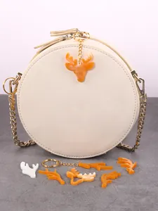 Detail of orange resin elk pendants and keychains on a cream round purse