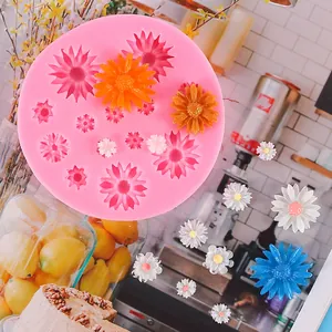 Detail view of pink daisy flower silicone mold with finished colorful resin daisies on background.