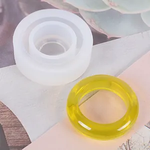 Dettaglio dello stampo in silicone tondo con un anello finito in resina gialla.