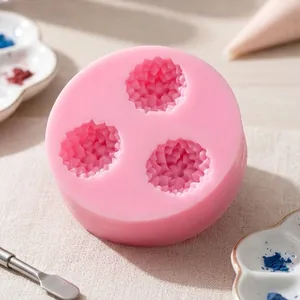 Gros plan sur un moule en silicone marguerite rose à trois cavités pour le chocolat et gâteaux