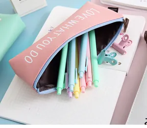 Detail view of pink PU leather pencil case open showing colorful pens inside
