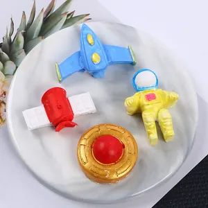 Close-up of 3D space-themed cake toppers including astronauts and rockets for DIY.