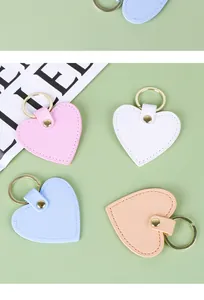 Collection de porte-clés en cuir en forme de cœur aux couleurs pastel sur fond vert